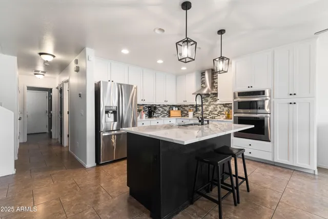 a kitchen with sink stove and white cabinets with wooden floor