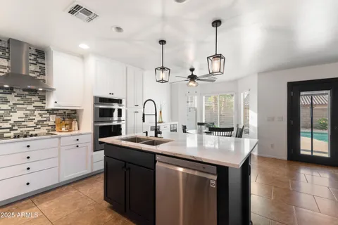 a kitchen with granite countertop white cabinets and stainless steel appliances