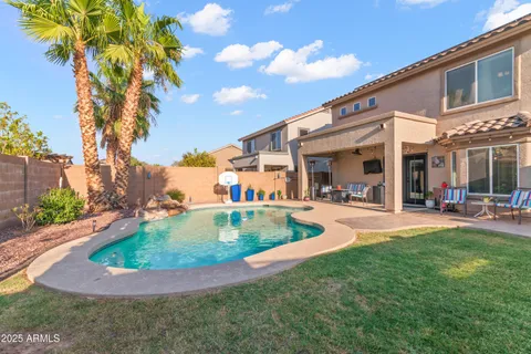 a view of a house with swimming pool and a yard