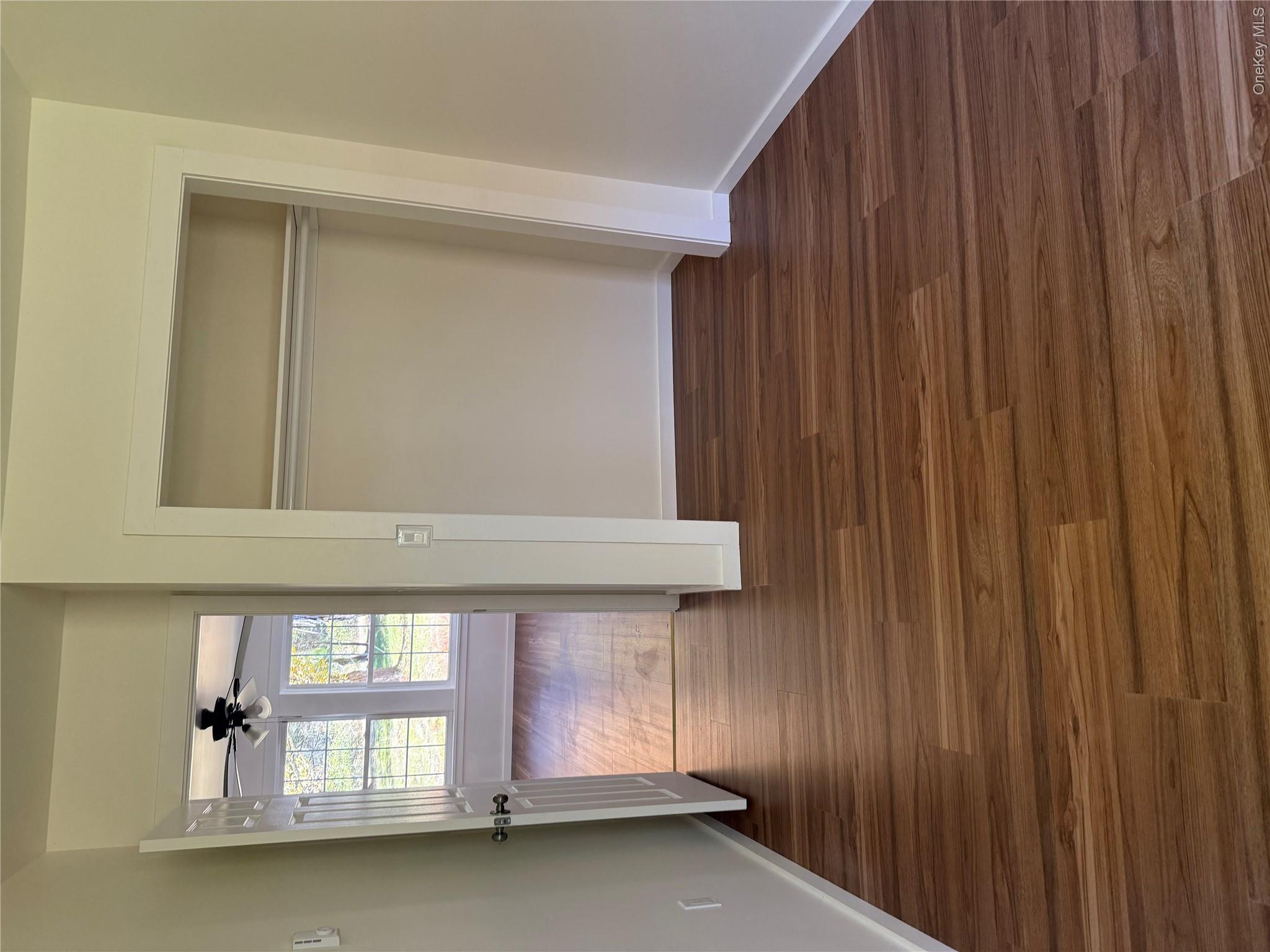 553 Cold Spring Road Monticello, NY 12701 - Photo 3 of 15 a view of an empty room with wooden floor and a window