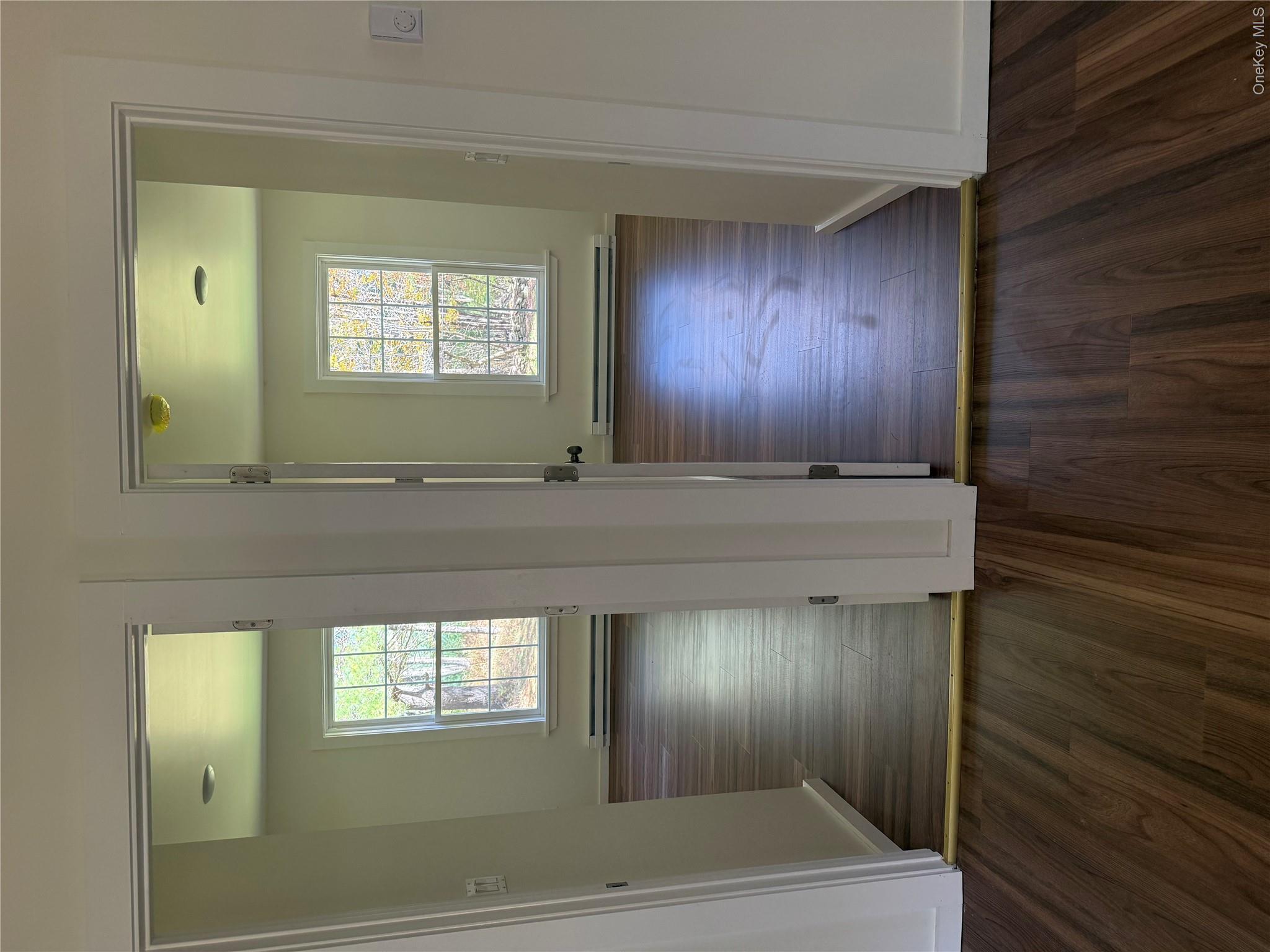 553 Cold Spring Road Monticello, NY 12701 - Photo 5 of 15 an empty room with wooden floor and windows