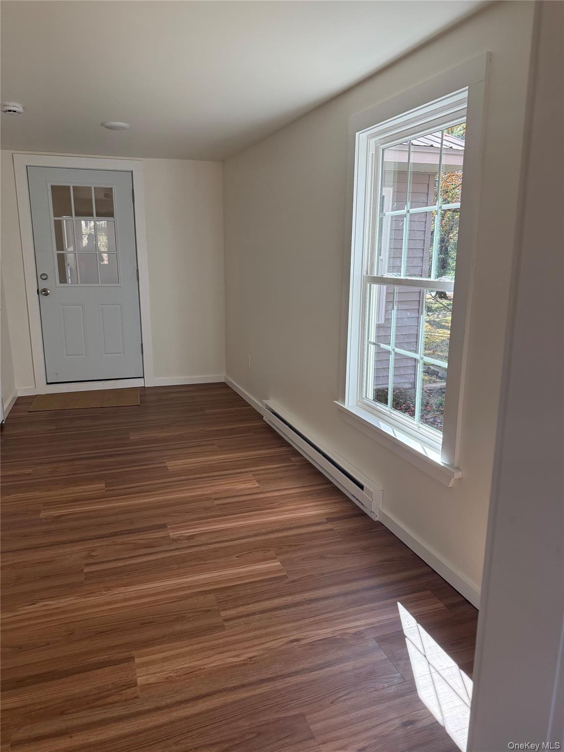553 Cold Spring Road Monticello, NY 12701 - Photo 8 of 15 a view of an empty room with wooden floor and a window