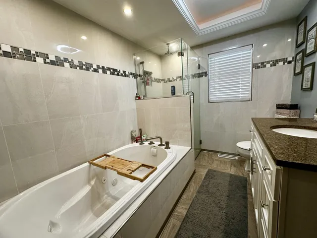 a bathroom with a tub sink and mirror