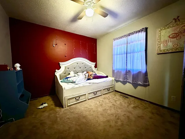 a spacious bedroom with a bed and a chandelier