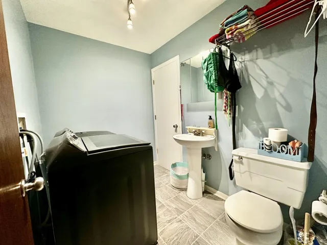 a bathroom with a toilet sink vanity and mirror