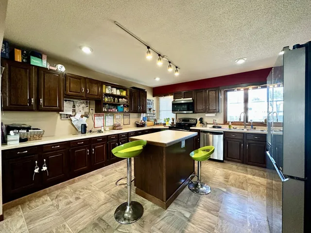 a kitchen with granite countertop a sink cabinets and stainless steel appliances
