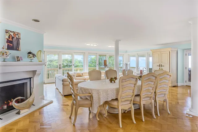 a view of a dining room with furniture a fireplace and wooden floor