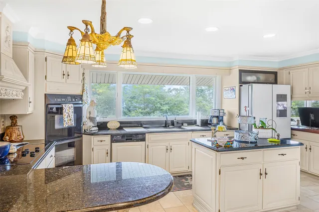 a kitchen with a stove a sink and a granite counter tops