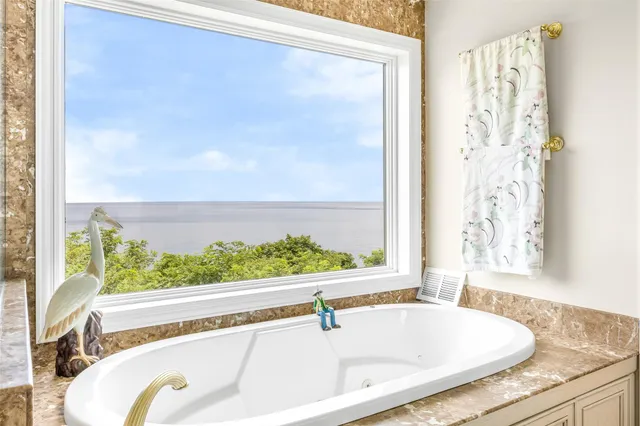 a bathroom with a tub and a large window