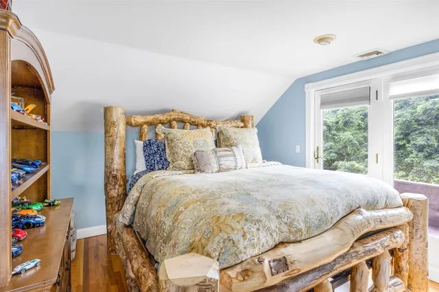 a large bed sitting in a bedroom next to a window