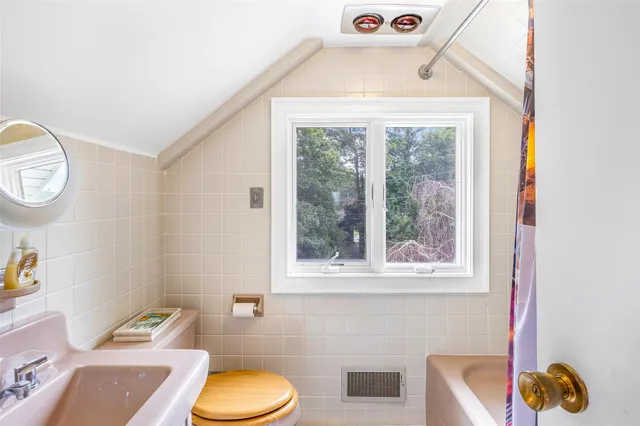 a bathroom with a toilet a sink and a window