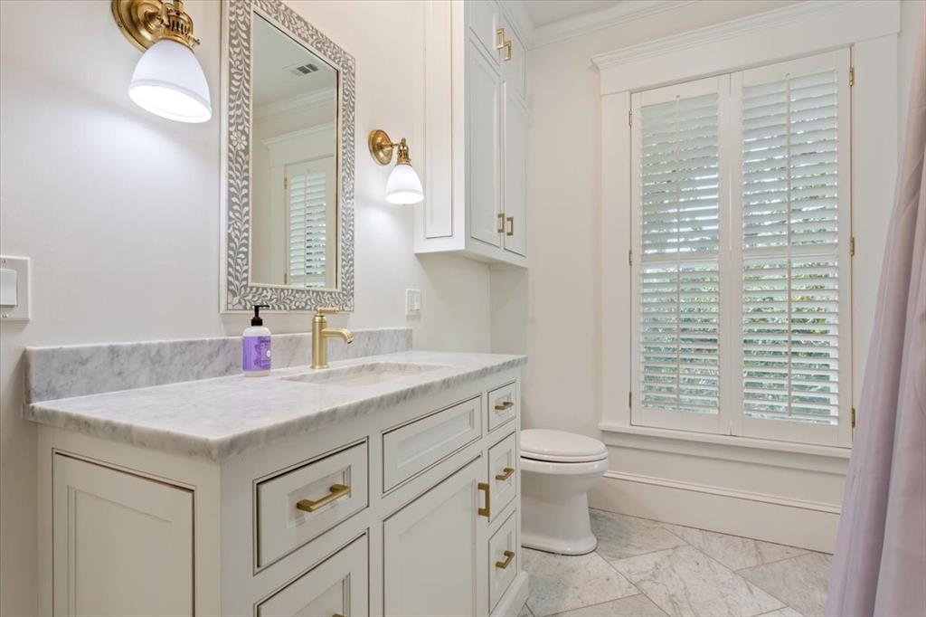 410 Rice Avenue Waco, TX 76708 - Photo 25 of 40 a bathroom with a granite countertop sink a toilet and a mirror