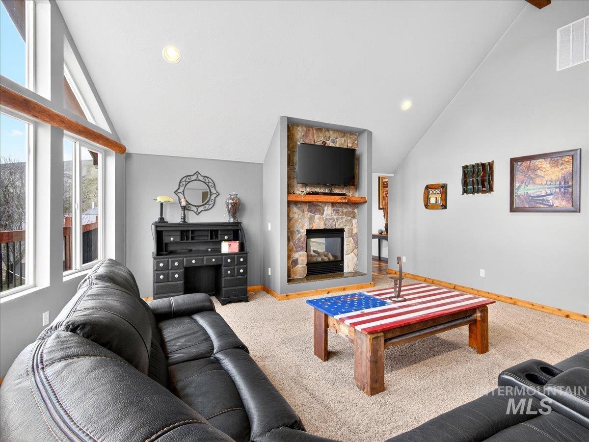 11714 Chukar Ridge Lane Horseshoe Bend, ID 83629 - Photo 13 of 50 Living area with a stone fireplace, lofted ceiling, carpet flooring, and recessed lighting