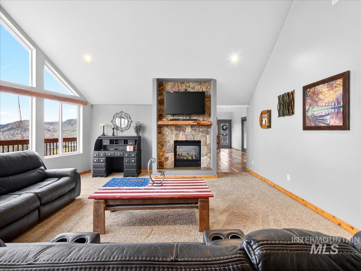11714 Chukar Ridge Lane Horseshoe Bend, ID 83629 - Photo 16 of 50 Living area featuring vaulted ceiling, light carpet, a stone fireplace, and recessed lighting