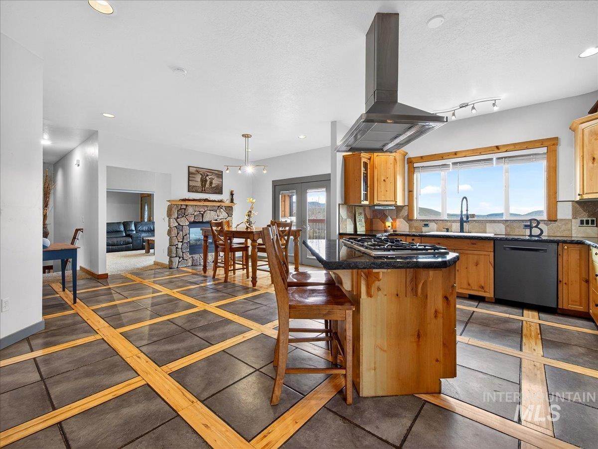 11714 Chukar Ridge Lane Horseshoe Bend, ID 83629 - Photo 23 of 50 Kitchen with extractor fan, a breakfast bar area, backsplash, and dishwashing machine