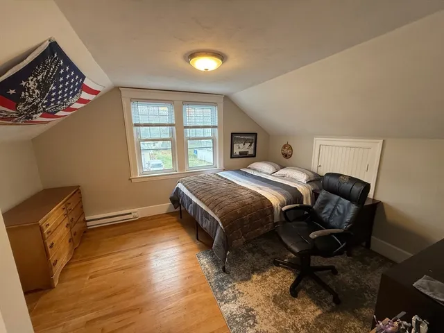 a bedroom with a bed chair and window