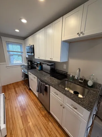 a kitchen with kitchen island granite countertop wooden cabinets and a stove