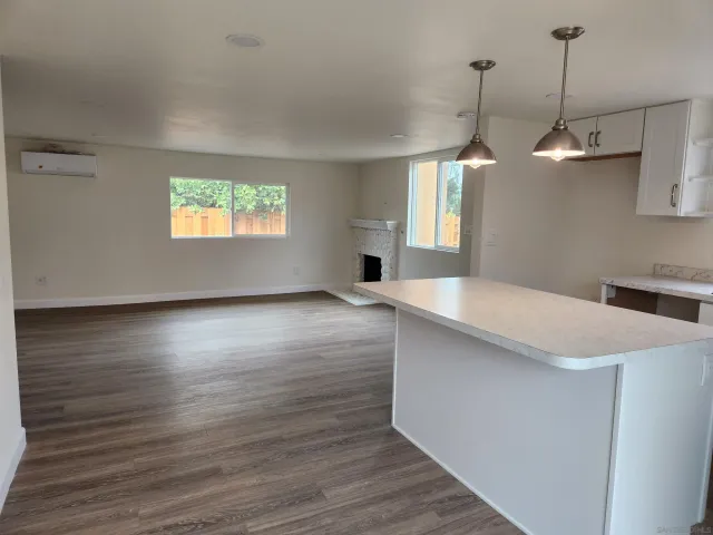 a view of a room with wooden floor chandelier and windows