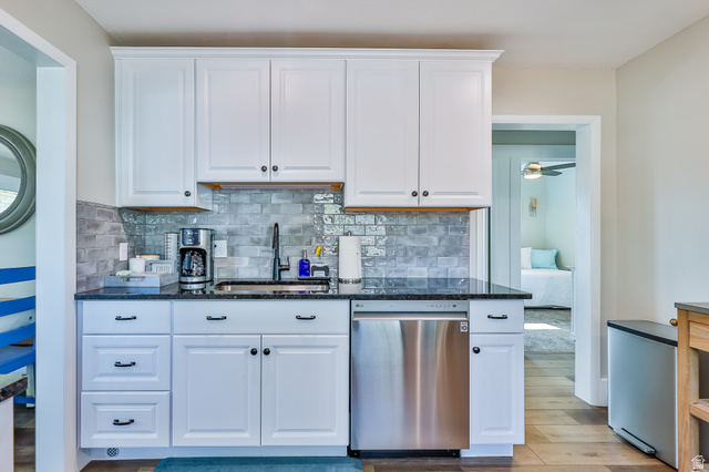 59 East 8680th Street South Sandy, UT 84070 - Photo 7 of 33 Compact kitchen featuring white cabinetry with dark hardware, granite-style countertops, and a subway tile backsplash