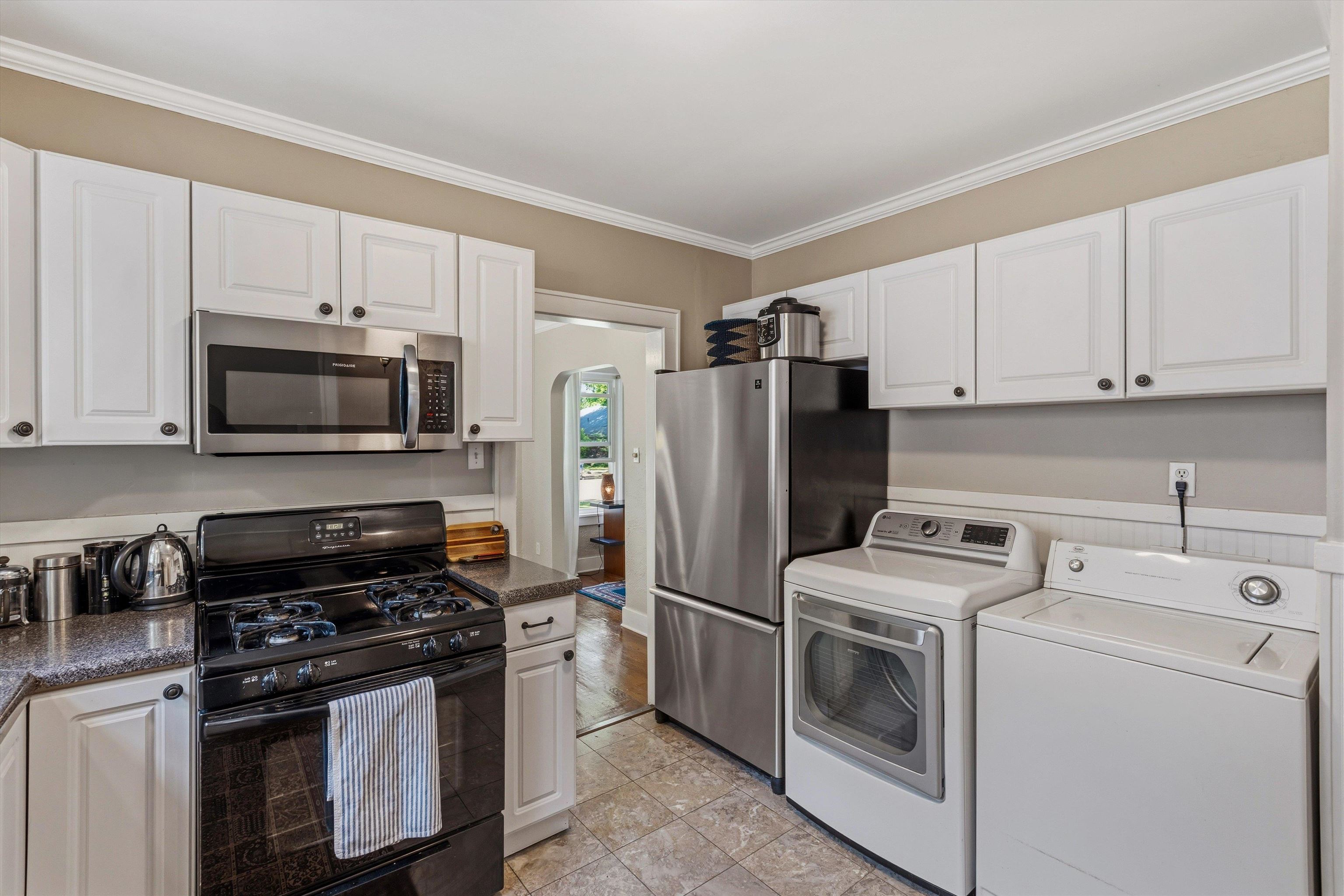 564 Alexander Street Memphis, TN 38111 - Photo 13 of 30 a kitchen with a stove microwave and refrigerator