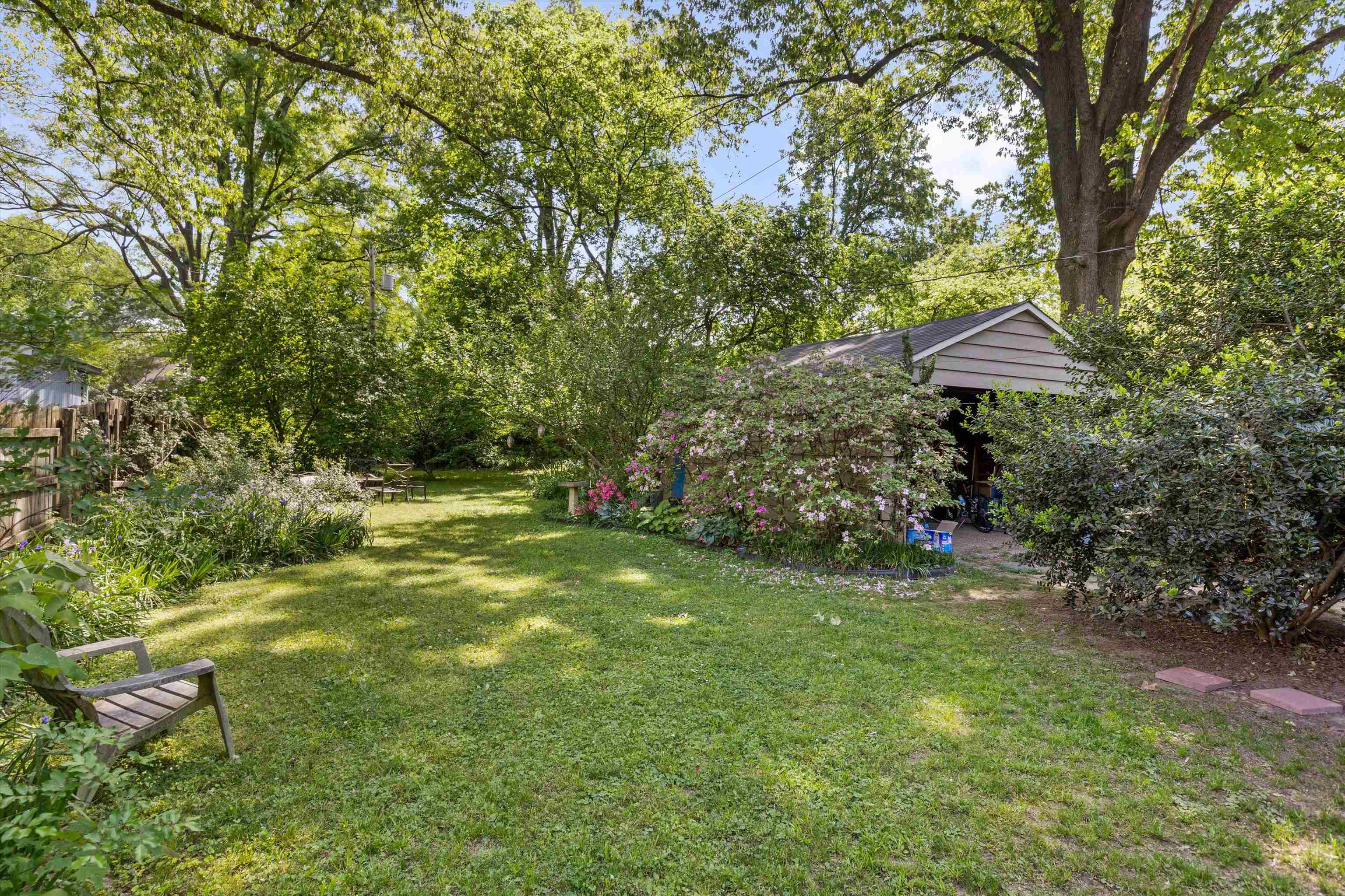 564 Alexander Street Memphis, TN 38111 - Photo 22 of 30 a view of a backyard with plants and a large tree