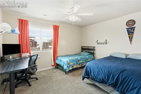 a bedroom with two beds and a desk