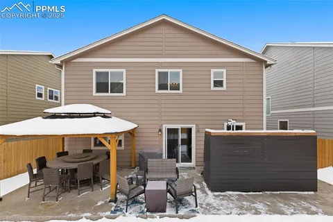 a backyard of a house with table and chairs