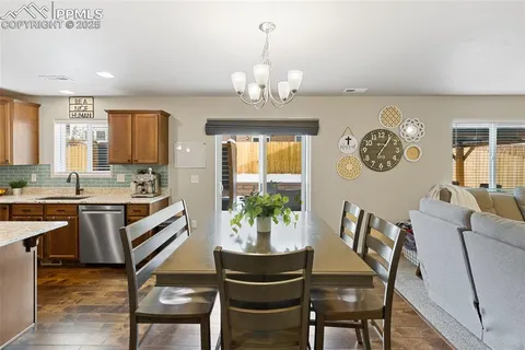 a view of a dining room with furniture a chandelier and wooden floor