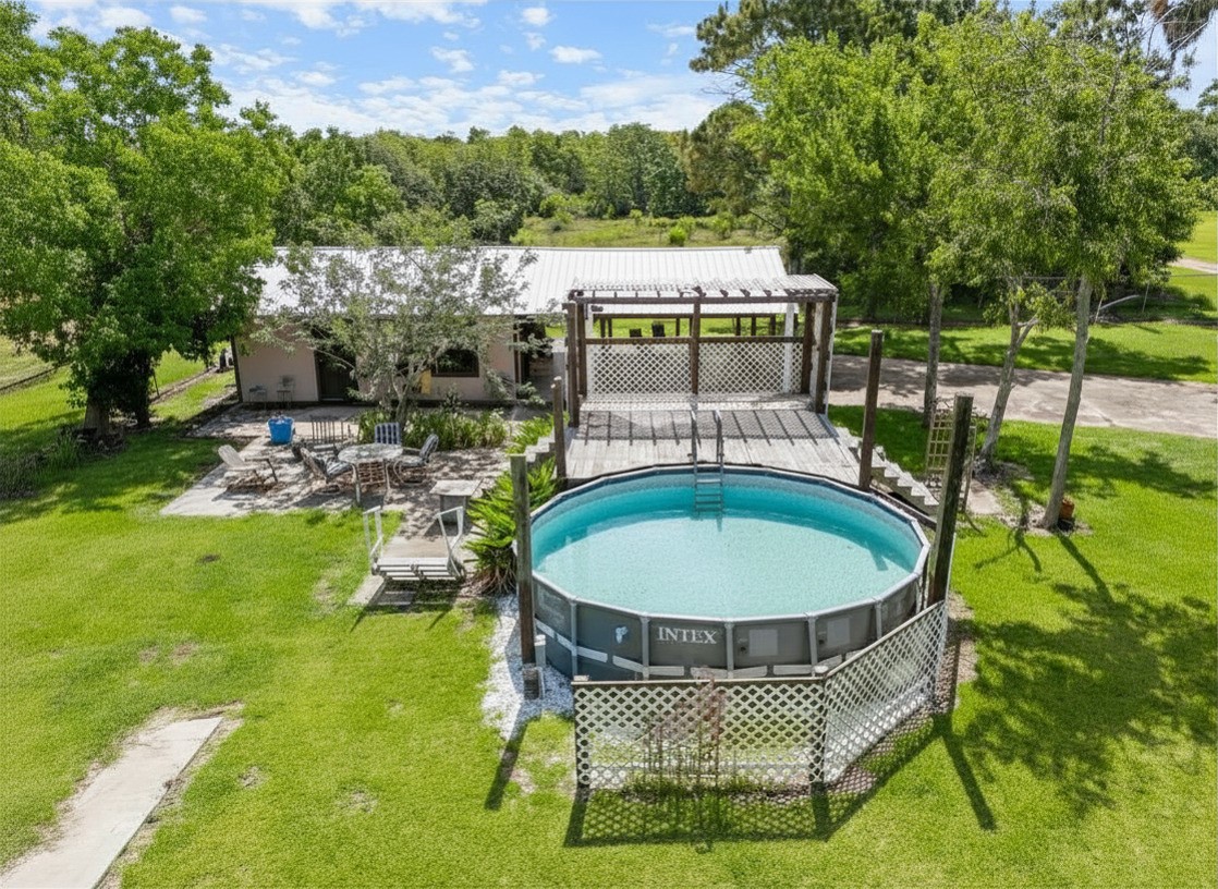 182 Smith Road Palacios, TX 77465 - Photo 2 of 23 a view of a swimming pool with a patio and a garden