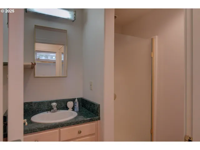 a bathroom with a granite countertop sink and a mirror