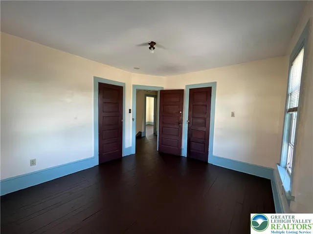 an empty room with wooden floor and closet