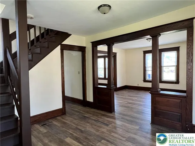 a view of a hallway with wooden floor and staircase