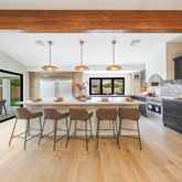 a living room with stainless steel appliances kitchen island granite countertop furniture and a wooden floor