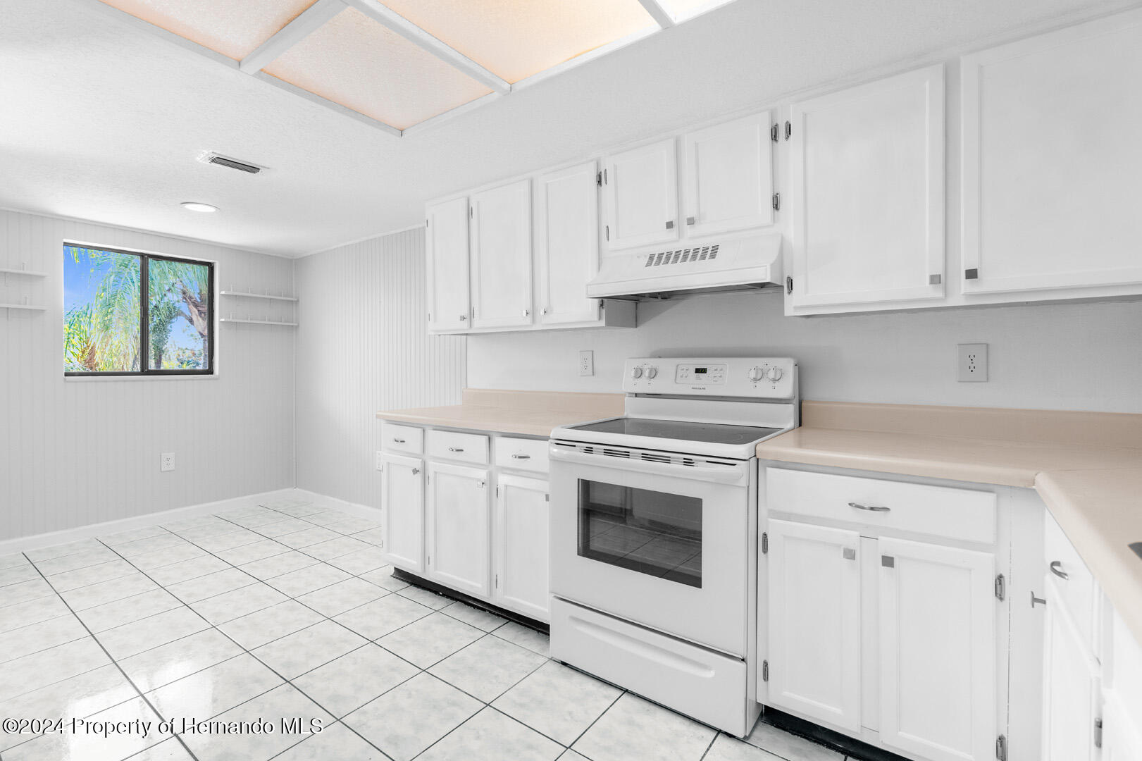 7721 Cosme Drive Hudson, FL 34667 - Photo 12 of 28 a kitchen with white cabinets and white appliances