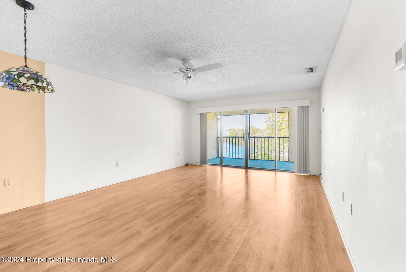 7721 Cosme Drive Hudson, FL 34667 - Photo 14 of 28 a view of an empty room with a window and wooden floor