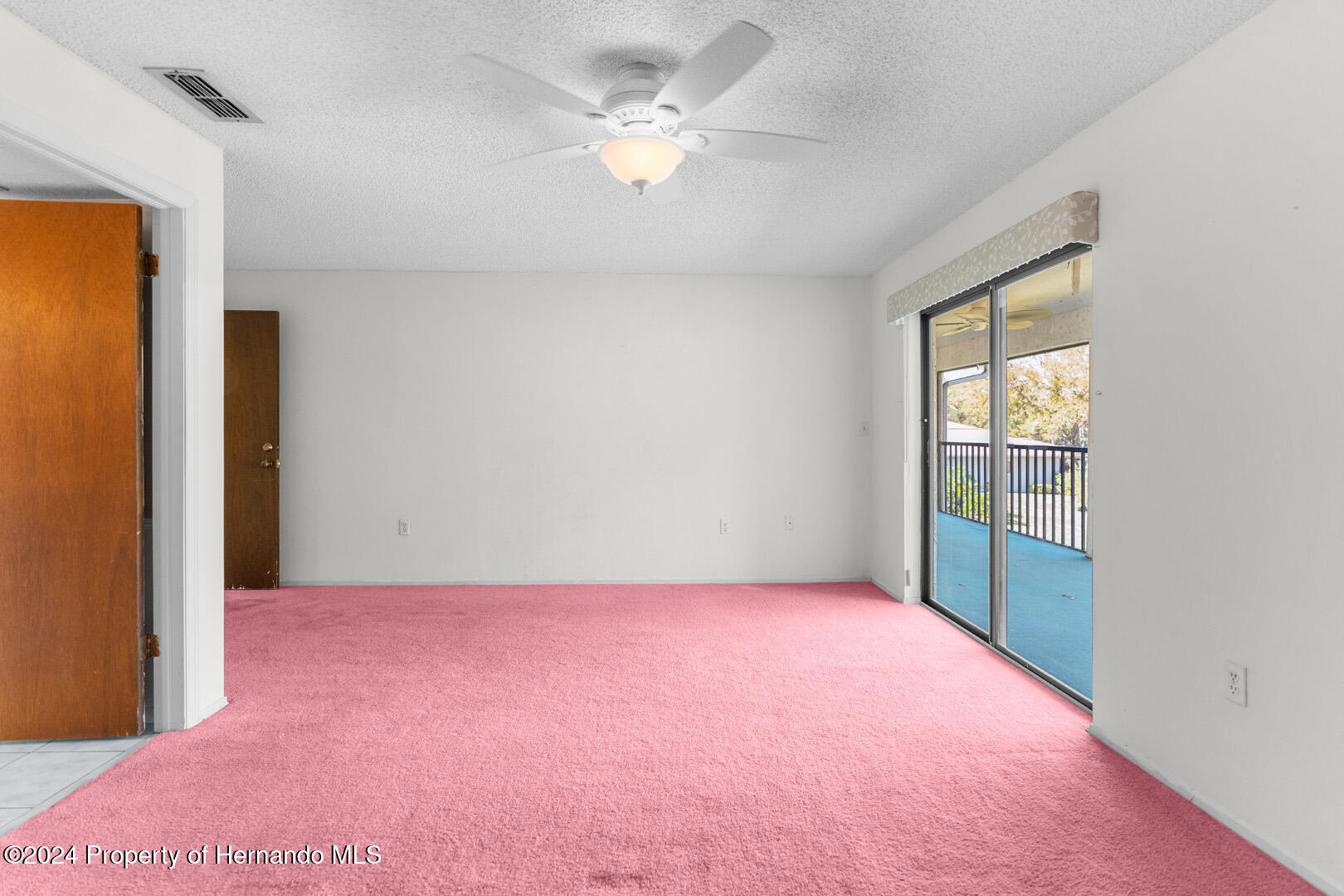7721 Cosme Drive Hudson, FL 34667 - Photo 19 of 28 an empty room with a window and a ceiling fan
