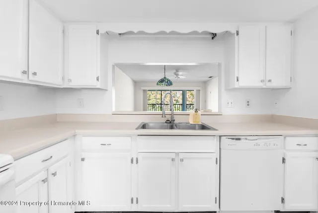 a kitchen with white cabinets and a sink