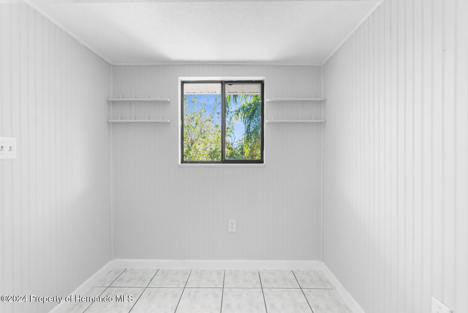 7721 Cosme Drive Hudson, FL 34667 - Photo 10 of 28 wooden floor in an empty room with a window