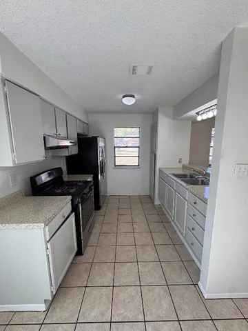 a kitchen with stainless steel appliances a sink stove and cabinets