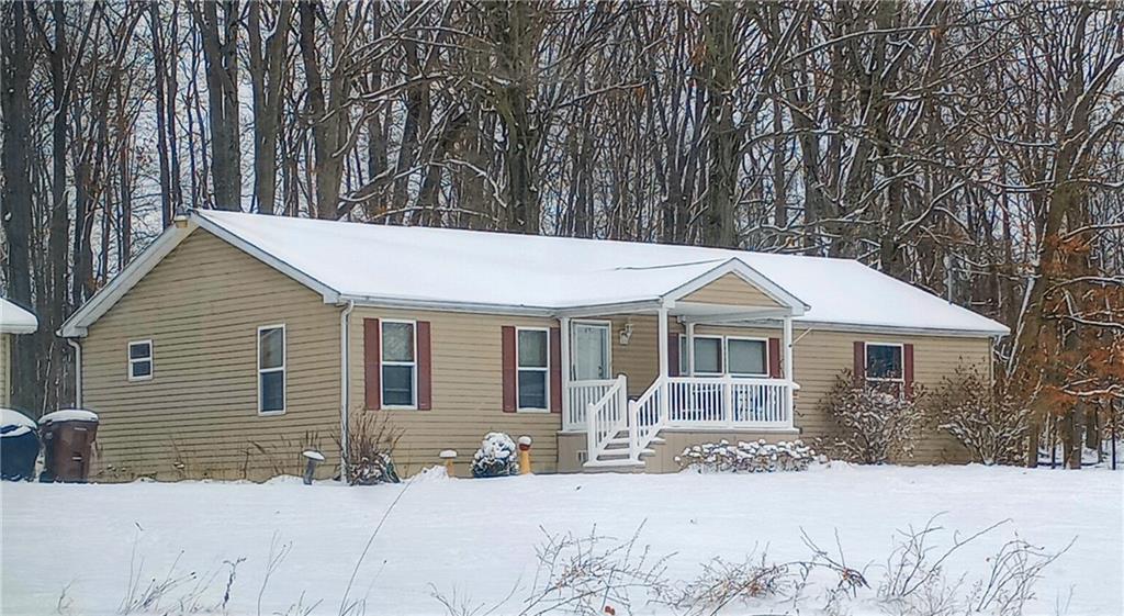 a front view of a house with a yard covered in snow