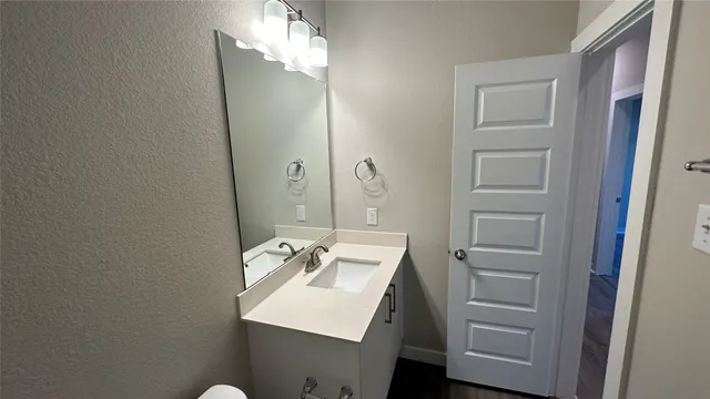 a bathroom with a sink a light fixture and a mirror