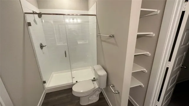 a white toilet sitting next to a shower
