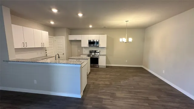 a large kitchen with stainless steel appliances granite countertop a stove a sink and a refrigerator