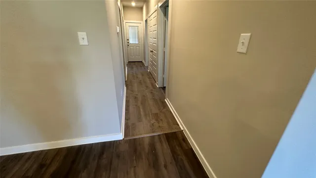 a view of a hallway with wooden floor and staircase