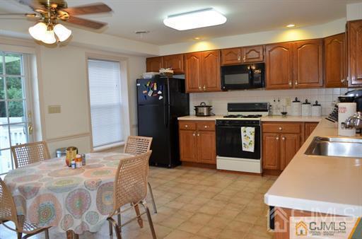596 Old Post Road Edison, NJ 08817 - Photo 10 of 13 a kitchen with stainless steel appliances granite countertop a sink dishwasher a stove a refrigerator with a dining table and chairs