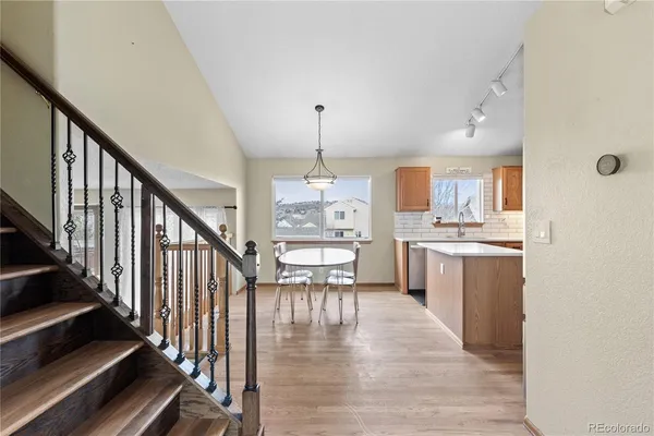 a view of a kitchen with wooden floor and electronic appliances