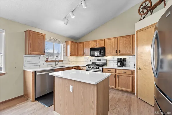 a kitchen with stainless steel appliances a sink stove refrigerator and cabinets