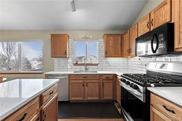 a kitchen with a sink stove top oven and cabinets