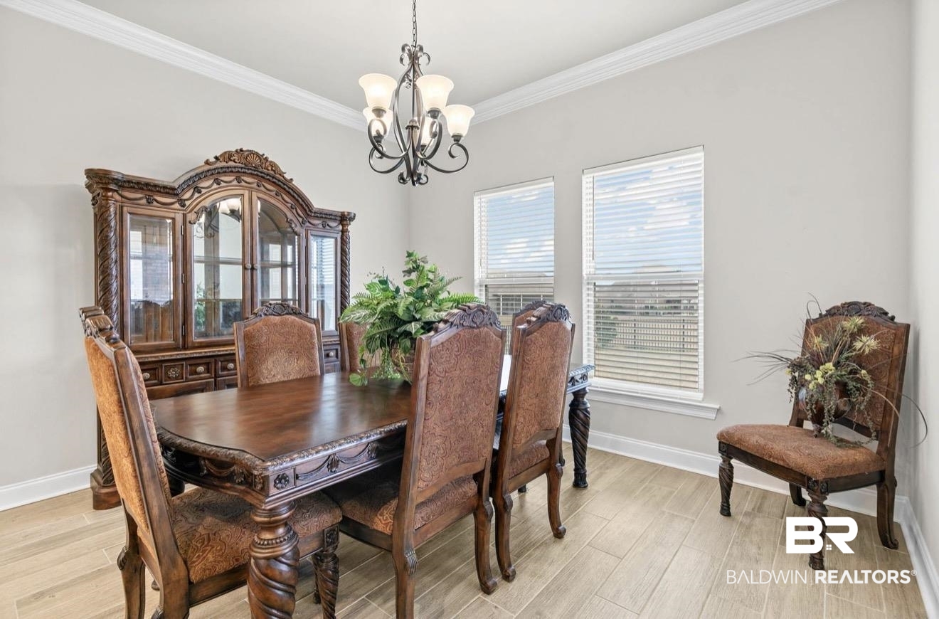 10126 Chipper Lane Foley, AL 36535 - Photo 11 of 30 Dining room with wood finish floors, ornamental molding, and a chandelier