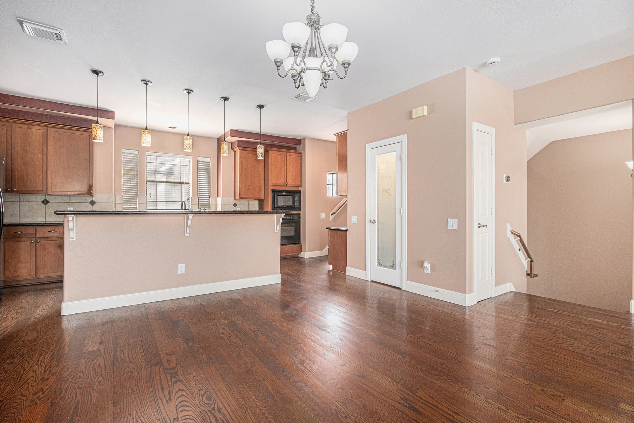 2402 Calumet Street, Unit B Houston, TX 77004 - Photo 13 of 44 a view of a kitchen with a refrigerator a ceiling fan and wooden floor